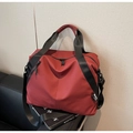 Detail of red and black waterproof travel bag with dual zippers and adjustable strap - Burgundy