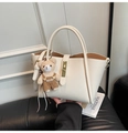 Detail of off-white lychee grain leather handbag with gold lock and bear charm - With Charm / Off White