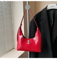 Detalle de bolso medialuna en charol rojo con un cierre giratorio de metal plateado - Rojo