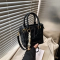 Secchiello nero in pelle con dettagli dorati e ciondolo intrecciato, portato a mano con stile - Nero