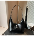 Detail of glossy black patent leather crescent bag with silver metallic turn-lock closure - Black