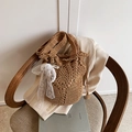 Brown crochet bucket bag with white lace bow and pearl charm on a vintage chair - Khaki with Pendant