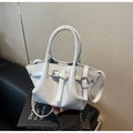 Détail d'un sac à main bleu clair en cuir avec boucles métal et doubles poignées - Bleu