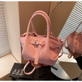 Pink patent leather bucket bag featuring decorative straps and silver metal buckles - Pink