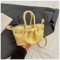 Detalle de bolso tipo cubo amarillo con hebilla decorativa y correa delgada ajustable - Amarillo