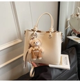 Détail du sac seau en cuir crème avec poignées et breloque en forme d'ours - Beige Avec Charme