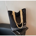 Macro detail of canvas texture on minimalist tote bag with stitched leather patch - Black