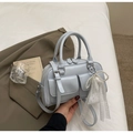 Detail view of light blue bowling bag with lace bow pendant and double front pockets - Blue