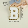 Detail of chenille letter B patch with gold glitter edge showing 8cm height dimension - Letter B / White / Hot Melt Adhesive