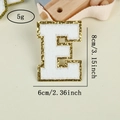 Detail of white chenille letter E patch with gold glitter edge and 8cm dimensions - Letter E / White / Hot Melt Adhesive