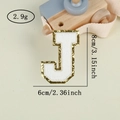 Macro shot of letter J towel embroidery patch with gold sequins and 8cm height dimension - Letter J / White / Hot Melt Adhesive