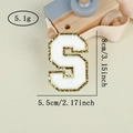 Detail view of Varsity letter S patch with white chenille fabric and gold sequins - Letter S / White / Hot Melt Adhesive