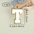 Detail of chenille letter T patch with gold glitter edge, 8cm height measurement - Letter T / White / Hot Melt Adhesive