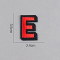 Détail de l'écusson brodé lettre E rouge et noir, dimensions de 3,5 cm sur 2,4 cm - Lettre E