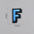 Détail de l'écusson brodé lettre F bleu ciel, dimensions 3,6cm par 2,4cm - Lettre F