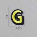 Vue détaillée de l'écusson brodé lettre G jaune avec dimensions de 4cm par 3,2cm - Lettre G