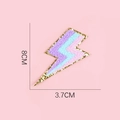 Dettaglio toppa ricamata a fulmine da 8cm con strisce rosa blu viola e paillettes dorate - Fulmine