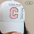 Close-up of pink chenille letter C patch with gold sequins on white baseball cap - Letter C / Pink / Hot Melt Adhesive