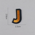 Détail de l'écusson brodé lettre J doré montrant les dimensions 2,8cm hauteur et 2,3cm largeur - Lettre J