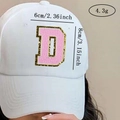 Detail of pink chenille letter D patch with gold sequins on a white baseball cap - Letter D / Pink / Hot Melt Adhesive