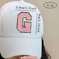 Detail view of pink chenille letter G patch with gold glitter edge on a white baseball cap - Letter G / Pink / Hot Melt Adhesive