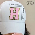 Close-up of pink chenille letter H patch with gold glitter edge on a white baseball cap - Letter H / Pink / Hot Melt Adhesive