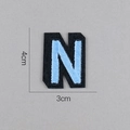 Détail de l'écusson brodé lettre N bleu clair avec support en feutre noir 4cm x 3cm - Lettre N