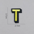 Détail de l'écusson brodé lettre T noir et jaune mesurant 3,7x2,7 cm pour vêtements - Lettre T