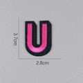Vue détaillée de l'écusson brodé lettre U rose avec bord noir, taille 3,7 x 2,8 cm - Lettre U