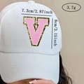 Detail of pink chenille letter V patch with gold glitter on a white baseball cap - Letter V / Pink / Hot Melt Adhesive