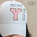 Detail view of 8cm pink chenille letter patch Y with gold sequins on a white cap - Letter Y / Pink / Hot Melt Adhesive
