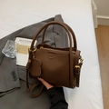 Dunkelbraune Eimer-Handtasche aus genarbtem Leder mit niedlichem Hundeanhänger - Kaffeebraun