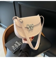 Detail showing the light pink saddle bag with a silver bow clasp on a black seat - Off White