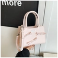 Detail van roze lederen handtas met decoratieve strikken met parels en verstelbare riem - Roze