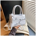 Detail of light blue crossbody bag featuring pearl bows and metal brand logo - Blue