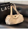 Grote beige canvas weekendtas met dubbele handvatten en lange riem op bank - Beigegrijs