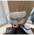 Light blue faux leather saddle bag featuring a polished silver bow-knot buckle detail - Blue