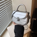 Silberne Satteltasche mit Kunstleder-Textur und elegantem Kettenriemen in der Hand - Silber