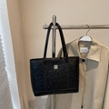Black embossed tote bag with cartoon pattern and silver logo hanging on a rack - Black without Pendant