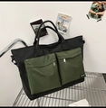 Dettaglio della borsa da viaggio grande in nylon con tasche con zip verde militare su rack - Nero & Verde