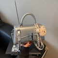 Schicke silberne Metallic-Handtasche mit Faltenstruktur, Drehverschluss und Bärenanhänger - Silber (Mit Anhänger)