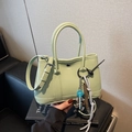 Pistaziengrüne Eimertasche aus Leder mit dekorativen Anhängern und Tragegriffen - Groß / Mit Anhänger / Grün