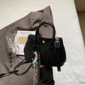Elegante schwarze Eimertasche aus Leder mit Narbenstruktur, Tragegriff und Quasten - Klein / Mit Anhänger / Schwarz