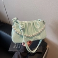Detail showing mint green pleated cloud bag with elegant pearl handle and leather strap - Green