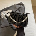 Detail of black ruched cloud bag with large pearl chain strap and leather shoulder strap - Black