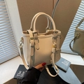 Elegant cream-colored litchi texture bucket bag with bear pendant and gold hardware - Off White