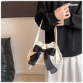 Detail of white corduroy handbag with large black bow and drawstring closure style - White