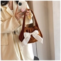 Close-up of brown corduroy handbag featuring a large white satin bow on shoulder strap - Dark Brown