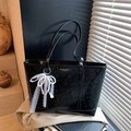 Elegante borsa tote in pelle nera goffrata con texture floreale e ciondolo in pizzo - Nero