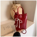 Detail of red glossy mini bucket bag with elegant white pearl bow charm and dual handles - Pearl Bow Red Glossy Style / Red